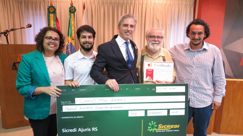 Diretor do Departamento de Direitos Humanos, Mauro Evely Vieira de Borba entrega o cheque